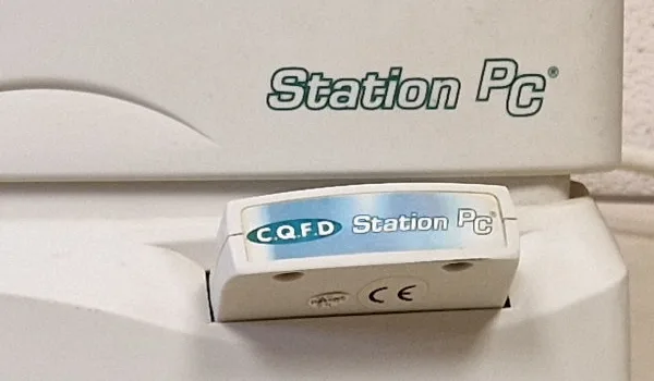 Cartouche d'extension blanche C.Q.F.D Station PC insérée dans la fente latérale de l'unité