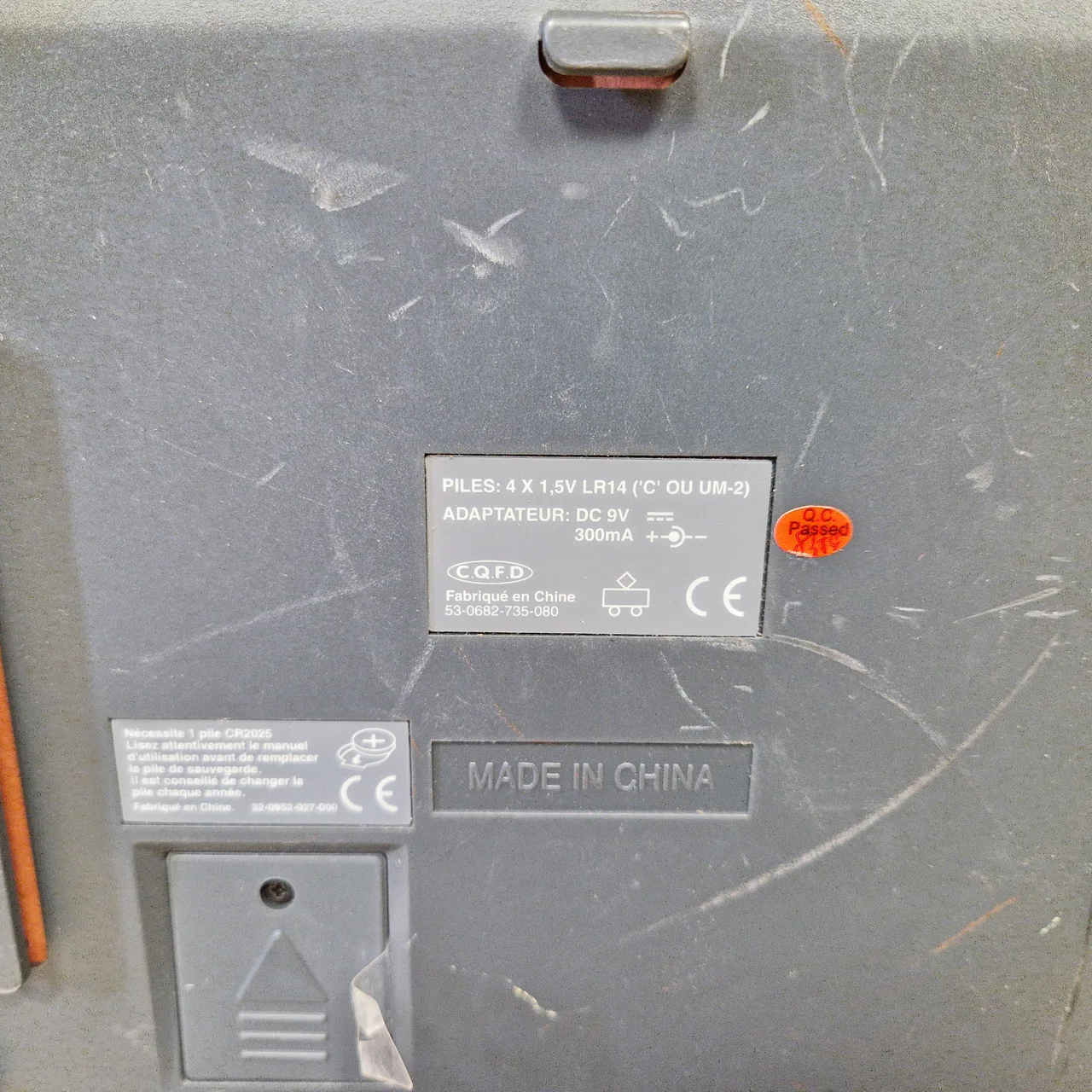 Dessous de la Station PC : plaque indiquant piles 4 x 1,5 V LR14, adaptateur 9 V 300 mA, logo C.Q.F.D, référence 53-0682-735-080, et étiquette de la pile de sauvegarde CR2025