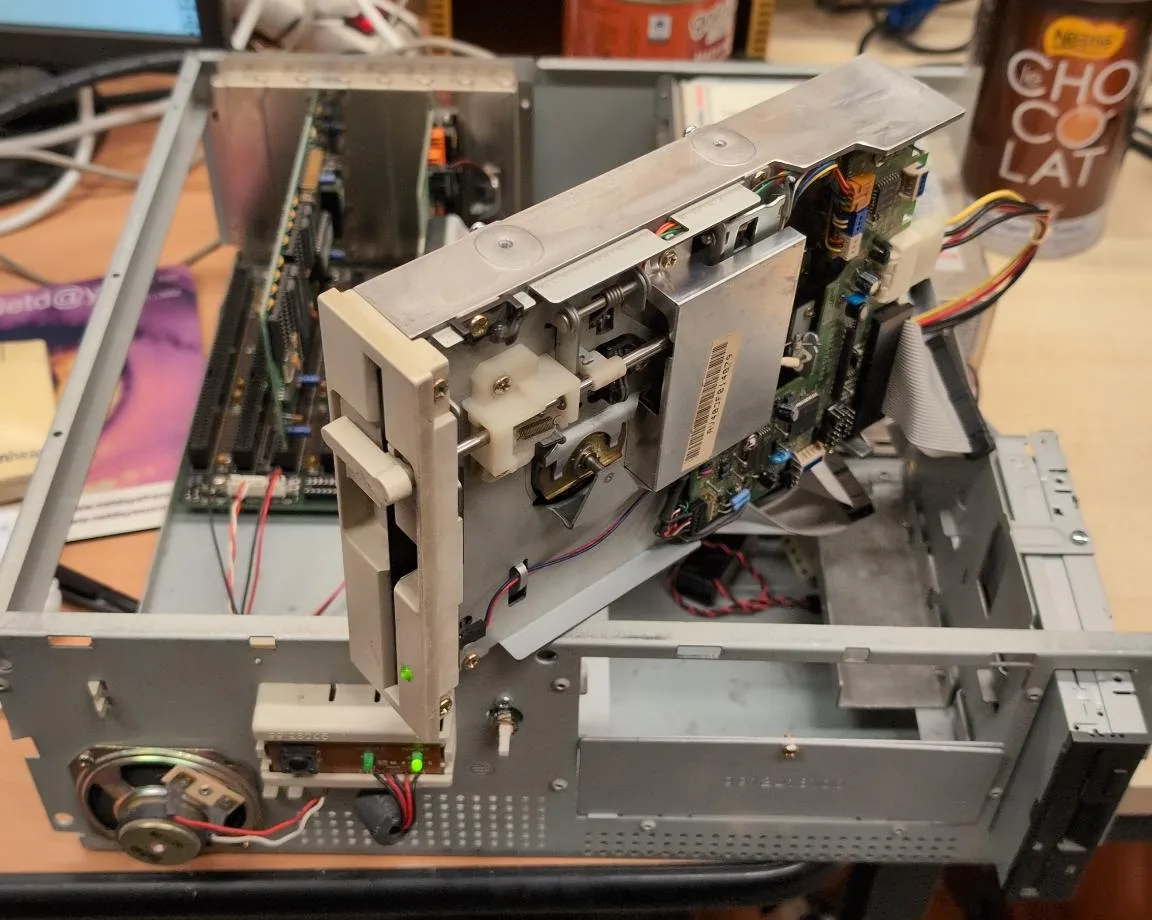 Lecteur 5 pouces 1/4 en fonctionnement, voyant vert allumé, monté hors boîtier sur un ancien PC ouvert